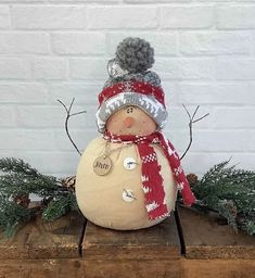 a snowman sitting on top of a piece of wood