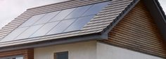 a house with a roof that has a solar panel on the top and two windows