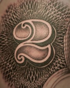 a tattoo design on the back of a man's shoulder, with swirls and circles