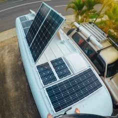 a solar panel on the roof of a car with a man standing next to it