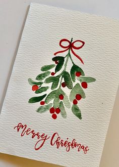 a christmas card with watercolor holly and red berries on white paper that says merry christmas