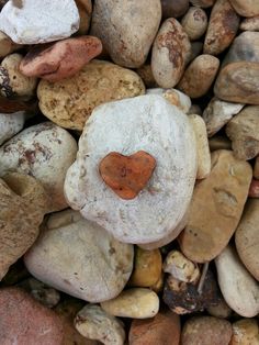 a heart shaped rock sitting on top of some rocks