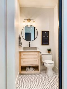 a bathroom with a toilet, sink and mirror in it's doorway way that leads to another room