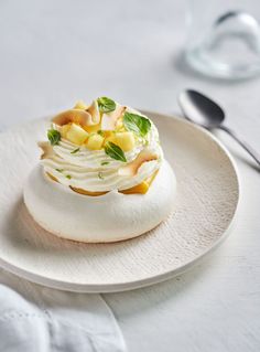 a white plate topped with a dessert covered in fruit