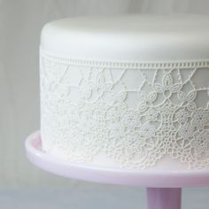 there is a white cake with lace on it