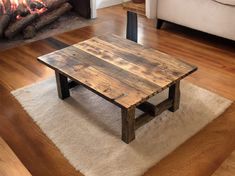 a wooden table sitting on top of a white rug in front of a fire place