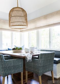 a dining room table with blue chairs and a basket hanging from the ceiling over it