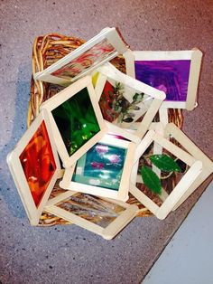 a basket filled with assorted pictures sitting on top of a cement floor next to a sidewalk