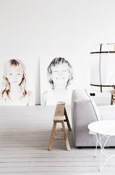 a living room with white walls and wooden flooring, two pictures on the wall