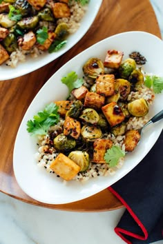 two white plates filled with food on top of a table