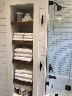 towels are stacked on shelves in the bathroom