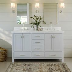 a bathroom with two sinks, mirrors and a rug in front of the sink area