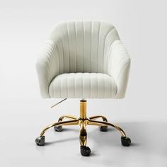 a white office chair with gold wheels and casteors on an isolated surface, in front of a gray background