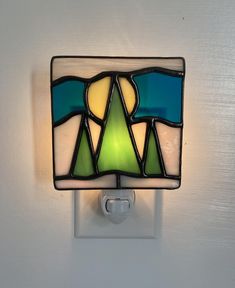 a stained glass night light on a white wall