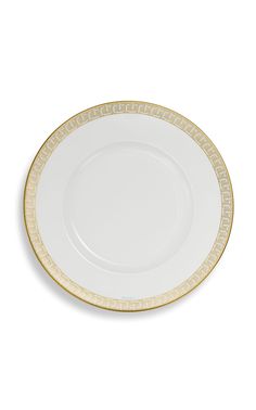 an empty white plate with gold trimmings on the rim and bottom, against a white background