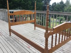 a wooden bed sitting on top of a wooden deck