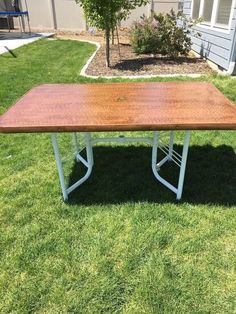 a wooden table sitting on top of green grass