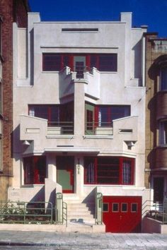 an apartment building with red doors and windows