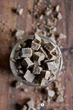 a glass cup filled with brownies on top of a wooden table