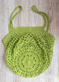 a green crocheted purse sitting on top of a wooden floor next to a white wall