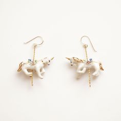 These porcelain unicorn earrings are handmade and hand painted with 24 ct gold.  The unicorn is embellished with Swarovski crystal detail.  Each piece is unique and hand finished.  Unicorn size: W3.2xH2.2xD1.3 cm. Come with sterling silver hooks.  This earrings will bring a magical touch to your wardrobe and will be perfect gift for your loved one. Jewellery Care: Our jewellery is made from porcelain and should be treated as fragile. We recommend that customers should always remove your jewellery when applying scent, lotions and potions, or even better, always put your jewellery on last when getting dressed. Please note that chlorine is especially damaging to jewellery. Ensure that you rinse off any chemicals that come into contact with your jewellery straight away to avoid build up which Poppy Ring, Unicorn Jewelry, Unicorn Earrings, Porcelain Earrings, White Unicorn, Merry Go Round, Animal Earrings, White Gold Necklaces, Stacked Jewelry