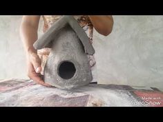 a person is making a bird house out of cement