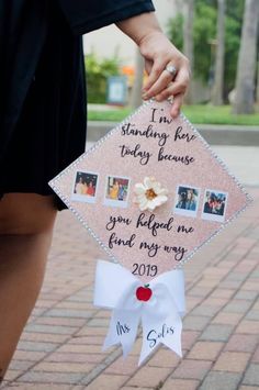 a person holding a pink graduation cap with pictures on it and the words i'm standing for today because you helped me find my way