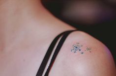 the back of a woman's shoulder with small flowers on it