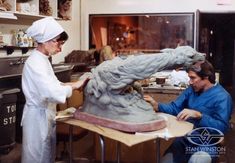 two women working on a statue in a kitchen