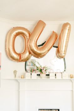 the balloons are shaped like the number 60 and the fireplace is decorated with pink flowers