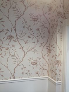 the corner of a bathroom with floral wallpaper