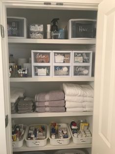 an organized closet with white linens and baskets