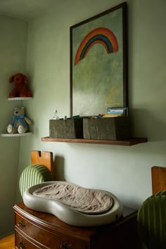 a baby's crib in the corner of a room with a painting on the wall