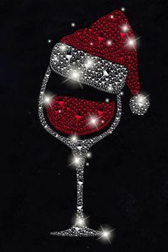 a red wine glass with a santa hat on it's head and sparkles in the background