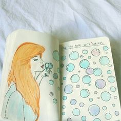 an open notebook with water bubbles and a drawing of a woman blowing bubbles on it