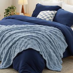 a bed with blue comforter and pillows on it