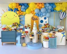 a room filled with balloons and desserts next to a blue dresser in front of a wall