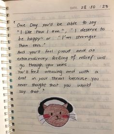 an open notebook with a drawing of a cat wearing headphones