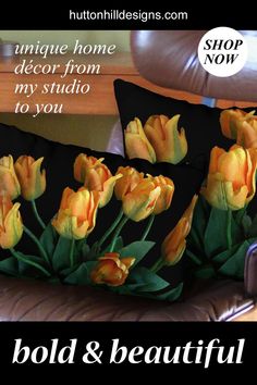 three pillows with yellow tulips on them in front of a brown leather couch