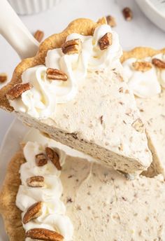 a piece of pie with whipped cream and pecans on top