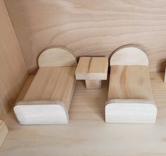 three pieces of wood sitting on top of a wooden floor next to each other in front of a wall