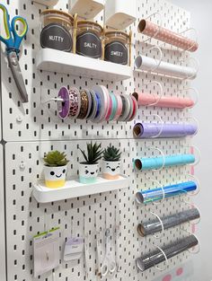 a wall mounted shelf filled with lots of craft supplies