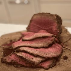 a piece of meat sitting on top of a wooden cutting board