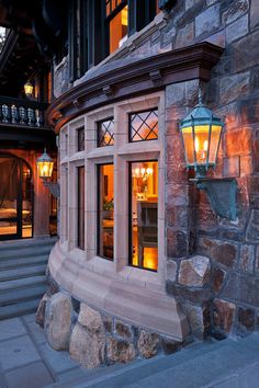 an outside view of a stone building with lights on