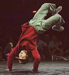 a man doing a handstand on top of another person in front of an audience