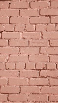 an old brick wall is painted pink