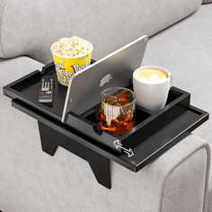 a tray that has food and drinks on it with a lap top in the middle