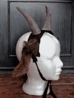 a white mannequin head with horns on it