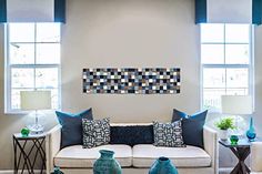 a living room filled with furniture and two windows covered in blue shades on the walls