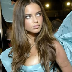 a beautiful young woman in a blue dress posing for the camera at a fashion show